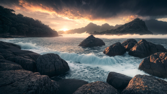 Sunset Serenity: Rugged Coastal Rocks and Crashing Waves