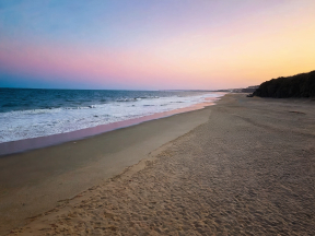 Serene Sunrise at a Secluded Coastal Beach with Gentle Waves and Vibrant Skies