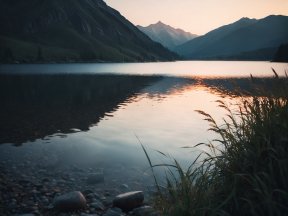 Serene Sunrise Over Layered Waters and Mountain Silhouettes
