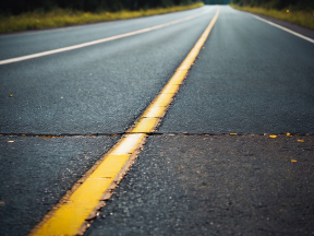 Empty Wet Road with Yellow Dividing Line in a Rural Setting