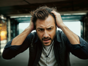 Person Showing Signs of Distress and Frustration in an Urban Outdoor Setting