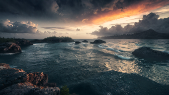 Stormy Seascape at Sunrise: Waves Crashing Against Rocky Shores Under Ominous Skies